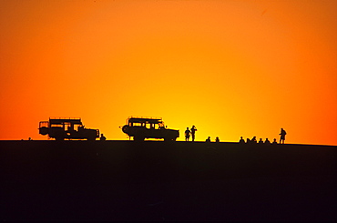 Jeeps and people at sunset, Walvis Bay, Namibia, Africa