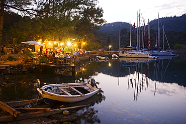 People on the terrace of a restaurant at a bay with jetty, Kapi Creek, Fethiye Bay, Turkey, Europe