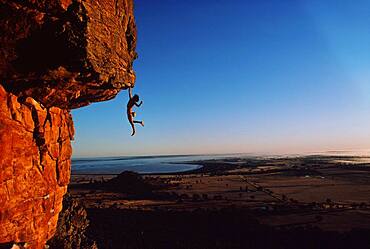 Freeclimber Stefan Glowacz hanging from rock, Mount Arapiles, Australia