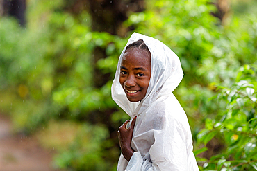 Young woman, girl with raincoat in the rain, southern Madagascar, Africa