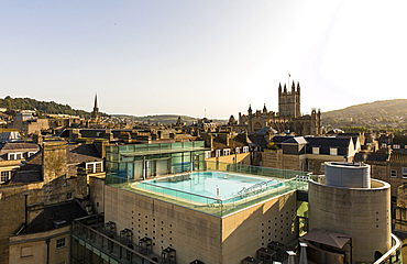 View of exterior roof-top pool set against the scenery of old turrets and buildgs, Horizontal. Bath. United Kingdom