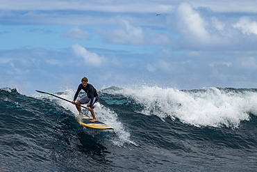 SUP stand up paddler on a breaking wave in the teahupoo surf area, Tahiti Iti, Tahiti, Windward Islands, French Polynesia, South Pacific