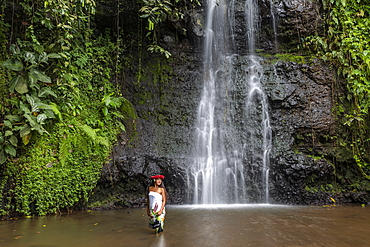 Beautiful young Tahitian woman in front of waterfall in 'The Water Gardens of Vaipahi', Teva I Uta, Tahiti, Windward Islands, French Polynesia, South Pacific