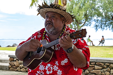 Man playing ukulele guitar and welcoming cruise ship passengers, Moorea, Windward Islands, French Polynesia, South Pacific