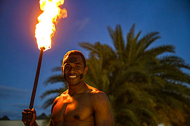 Friendly Fijian "warrior" with torch to light Tiki torches at Pullman Nadi Bay Resort