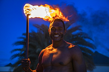 Friendly Fijian "warrior" with torch to light Tiki torches at Pullman Nadi Bay Resort