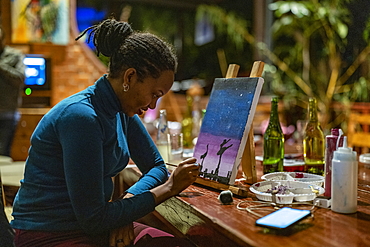 Woman paints picture during painting class event at Heaven Restaurant, Kigali, Kigali Province, Rwanda, Africa