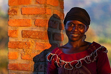 Portrait of a smiling Rwandan woman in late afternoon light, Kinunu, Western Province, Rwanda, Africa