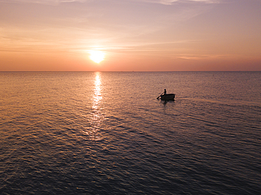 Aerial view silhouette of fisherman in traditional round boat at sunset, Ong Lang, Phu Quoc Island, Kien Giang, Vietnam, Asia