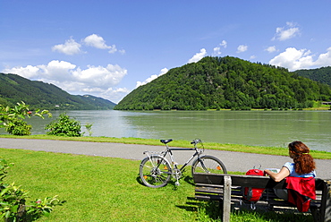 Woman sitting on a bench, Schloegener Schlinge, Danube cycle route Passau to Vienna, Schloegen, Upper Austria, Austria