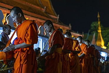 Barefoot monks collect early morning food and drink alms (sai bat), Luang Prabang, Luang Prabang Province, Laos, Asia