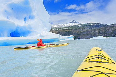 Kayaker paddling near icebergs, Torres del Paine National Park, Chile, South America