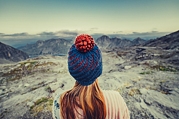 Woman with a hat stands on a mountain near Lünersee, Vorarlberg, Austria, Europe