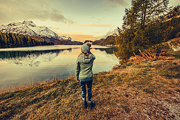 Woman at sunrise on Lake Sils, Engadin, Grisons, Switzerland, Europe