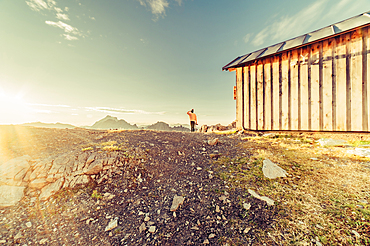 Woman with camera at sunrise in the mountains in Raetikon, Vorarlberg, Austria, Europe