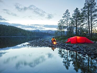 Red tent, man, campfire, Sefrivatnet, Tosfjellet, Nordland, Norway