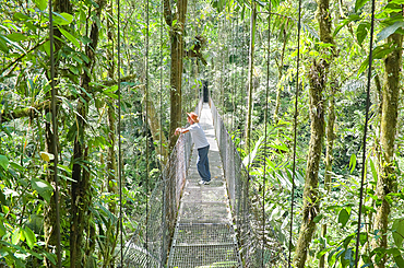 Man standing on hanging bridge, Arenal Volcano National Park, La Fortuna, Costa Rica