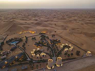 Aerial view of Arabian Nights Village desert resort amid dunes at sunset, Arabian Nights Village, Razeen Area of Al Khatim, Abu Dhabi, United Arab Emirates, Middle East