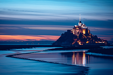 Evening view of the rocky island of Mont Saint Michel with the monastery of the same name, Normandy, France.