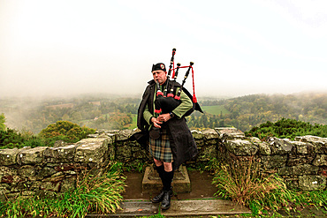 Bagpiper in the rain, at Scott's View, Borders, Scotland, UK