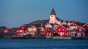 Red houses with a church in the village of Skärhamn on the archipelago island of Tjörn on the west coast of Sweden, in the evening