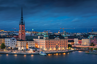 Illuminated skyline of Stockholm at night with Riddarholmskyrkan church on Gamla Stan old town island in Sweden