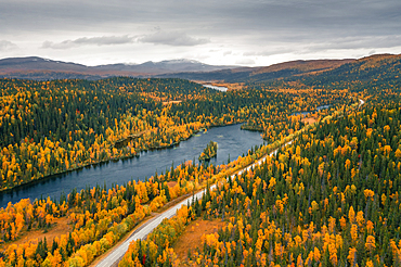 Panoramic Wilderness Road along a river, with mountains and trees in autumn in Jämtland in Sweden from above