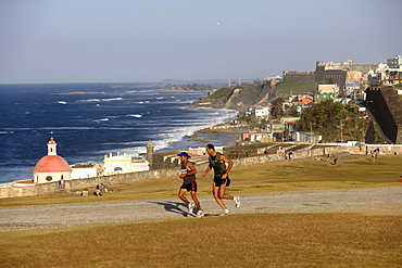 Two joggers at the park in front of castillo San Felipe del Morro, view over the north coast, San Juan, Puerto Rico, Carribean, America