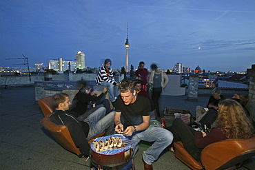 Rooftop party, young people, Prenzlauer Berg with view of night skyline, TV tower, Berlin, Germany