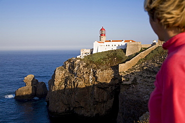 Young woman at the lighthouse at Cape Cabo de Sao Vicente, Atlantic Ocean, MR, Sagres, Algarve, Portugal