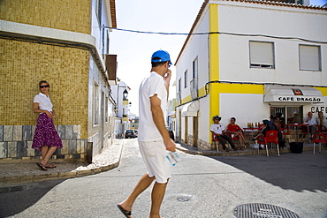 Street in Alvor, young women and men in a cafe, siesta, Alvor, Algarve, Portugal