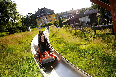 Tourists on the summer toboggan run in Karpacz, Bohemian mountains, Lower-Silesia, Poland, Europe