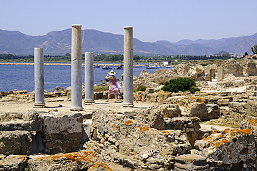 A woman at the excavations of the antique town Nora, South Sardinia, Italy, Europe