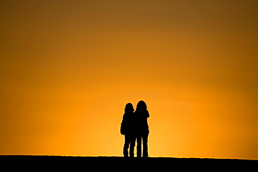 Two women watching the sunset, Puerto de Tazacorte, UNESCO Biosphere Reserve, La Palma, Canary Islands, Spain, Europe