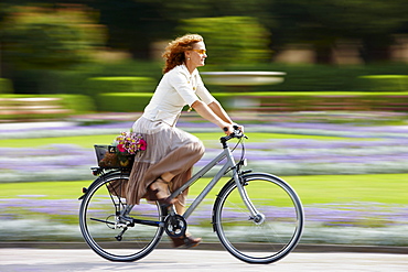 Mature woman riding bicyle, Munich, Bavaria, Germany