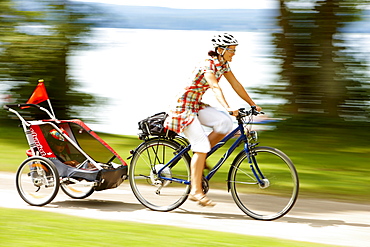 Cyclist with child trailer, Lake Starnberg, Bavaria, Germany