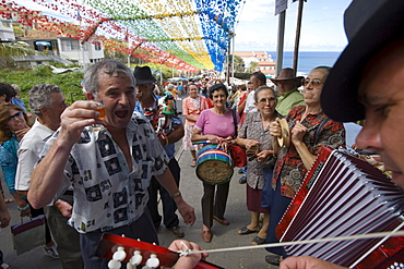 Man enjoying a glass of Madeira wine and listening to the Filarmonica Band playing at the religious festival, Ponta Delgada, Madeira, Portugal