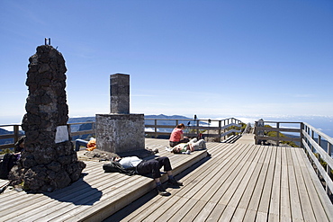 Hikers taking a rest on the summit platform of Pico Ruivo Mountain, Pico Ruivo, Madeira, Portugal