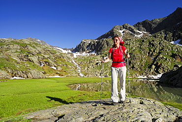 Woman hiking along lake Stubensee, Stubai Alps, Trentino-Alto Adige/South Tyrol, Italy