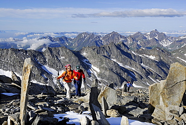 Three mountain hikers ascending to mount Hochfeiler, Zillertal Alps, South Tyrol, Italy