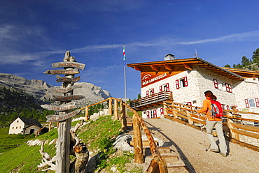 Woman arriving alpine hut Lavarella, Fanesalm, Naturpark Fanes-Sennes-Prags, Dolomites, Trentino-Alto Adige/South Tyrol, Italy