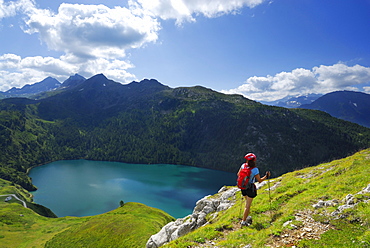 Woman hiking above reservoir Lago Ritom, Ticino Alps, Canto of Ticino, Switzerland