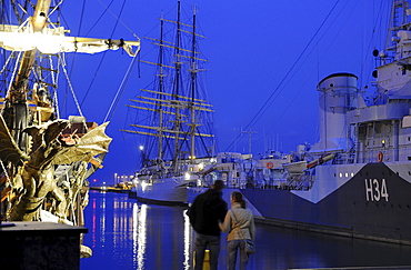 A couple in front of the museumship Dar Pormorza in Gdynia in the evening, Poland, Europe