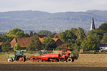 tractor working in the field, village, agriculture, rural landscape, northern Germany