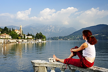 Woman enjoying view over Lake Como to Tremezzo, Lombardy, Italy