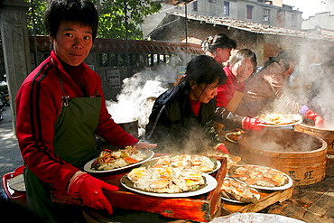 Waitress with steaming plates of sea food, steaming in bamboo baskets, Chinese cuisine, Jinfeng, Changle, Fujian province, China, Asia