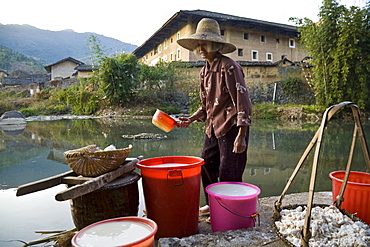 Chinese farmer fetching water from a small stream, village of the Hakka, Hongkeng, Longyan, Fujian, China, Asia