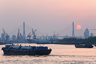 Ships on Huangpu River and cranes at the harbour at sunset, Pudong, Shanghai, China, Asia