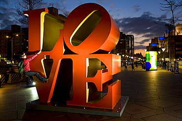 LOVE art installation in front of skyscraper Taipei 101, young German woman climbing on huge letters, Taipei, Republic of China, Taiwan, Asia