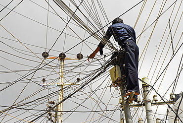 Electrician in a ravel of wires in dowtown Hyderabad, Andhra Pradesh, India, Asia